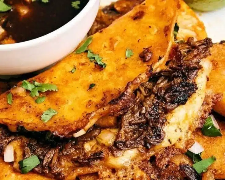 Delicious Beef Birria Tacos served with sauce and toppings