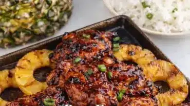 Delicious Huli Huli Chicken served on a grill with fresh herbs