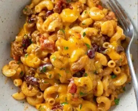 Delicious Chili Mac and Cheese Pasta topped with shredded cheese and herbs