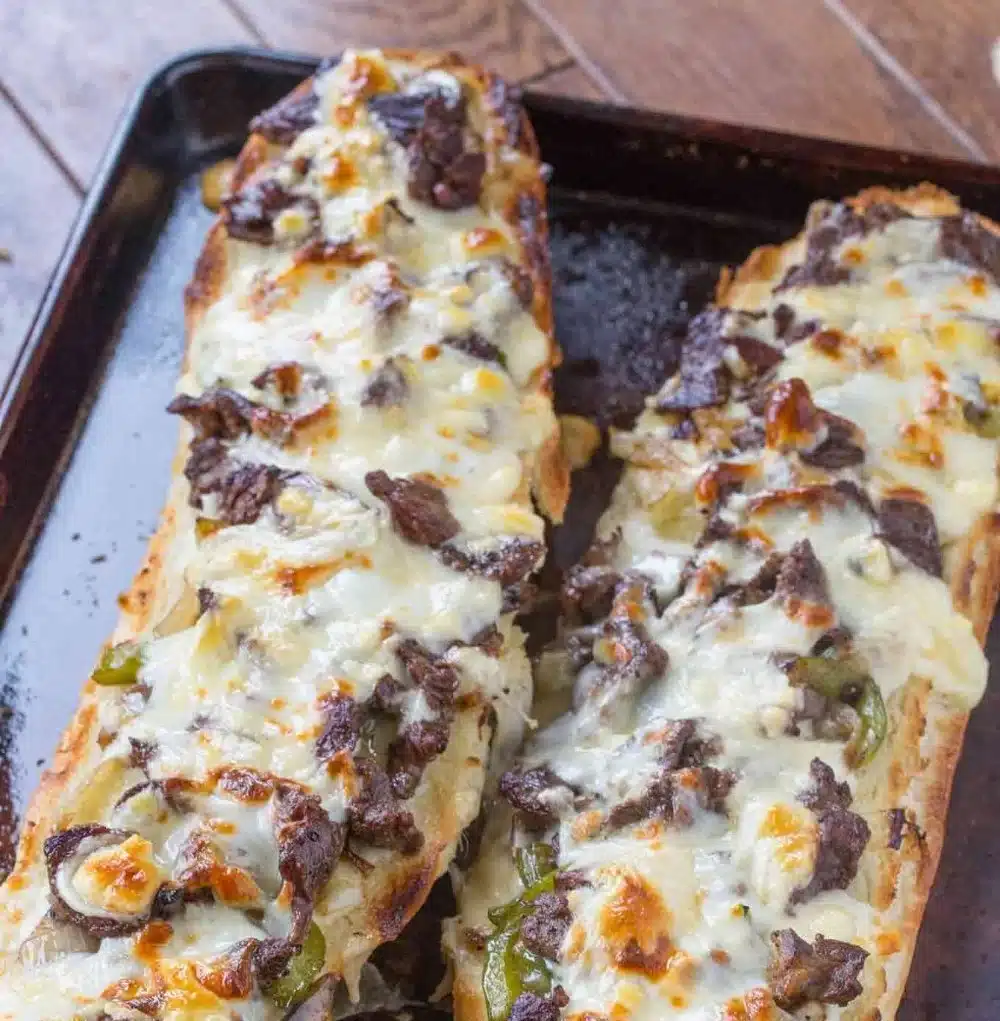 Philly cheesesteak cheesy bread topped with melted cheese and savory steak