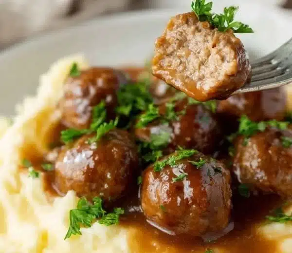 Plate of Salisbury Steak Meatballs garnished with herbs and served with gravy