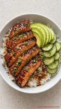 Delicious sticky teriyaki salmon bowl garnished with green onions and sesame seeds